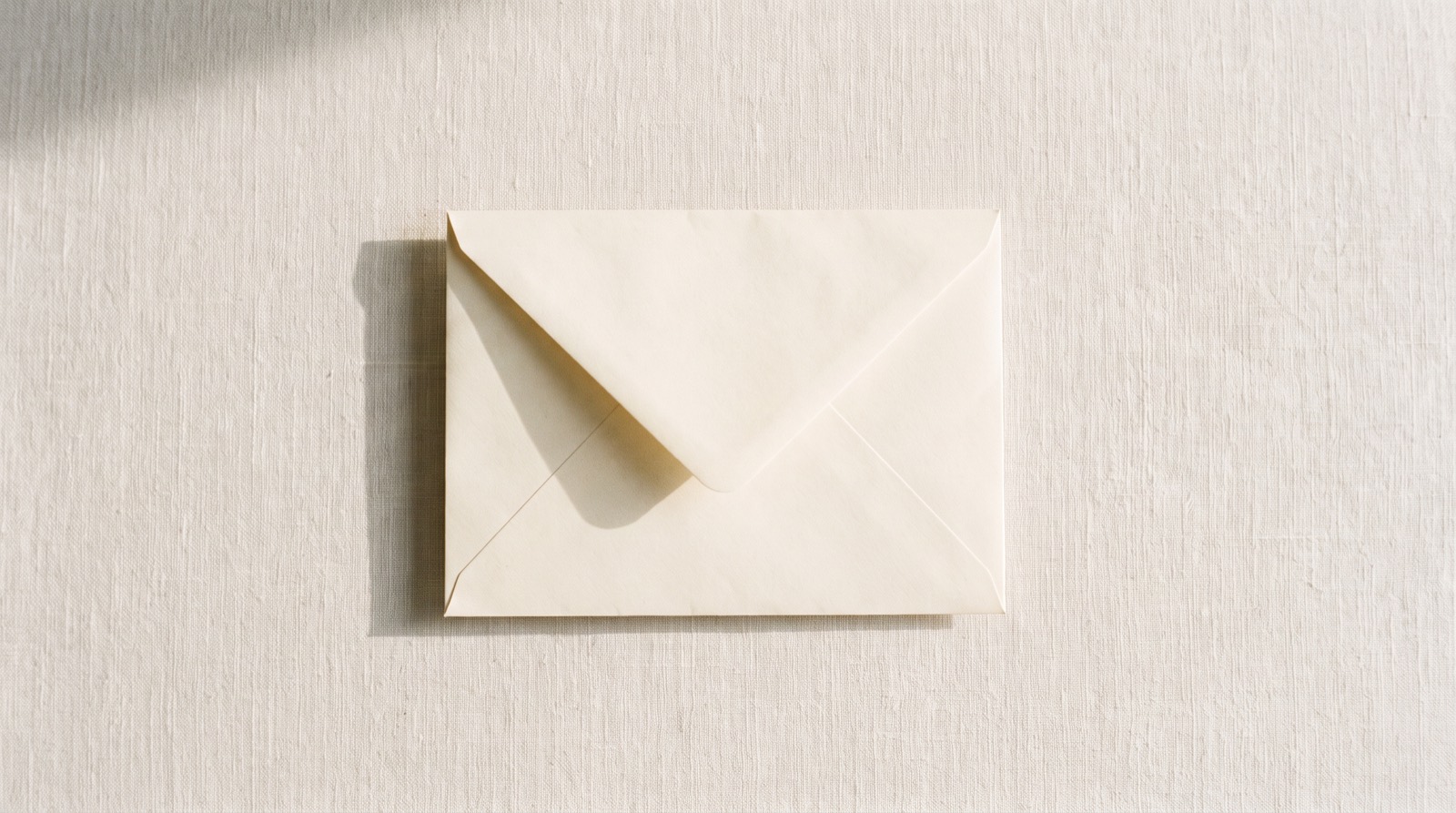 A plain unmarked cream envelope on linen